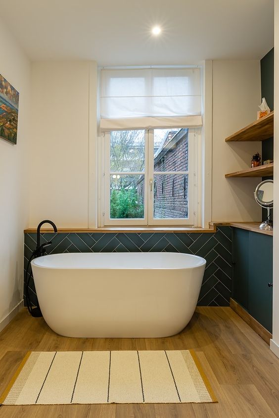 Une salle de bain design bleu canard et parquet en bois