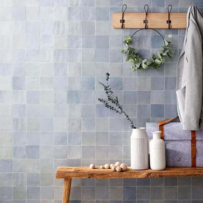 Une salle de bain avec un mur en carrelage zellige bleu