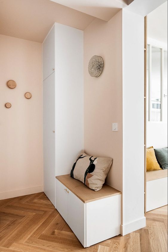 Une entrée rose pale avec banc et rangement design