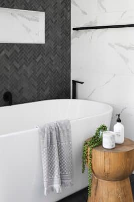 Une salle de bain cocooning avec baignoire et meuble bois 