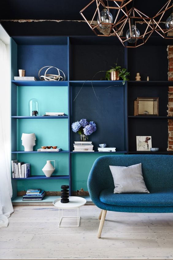 Un salon avec une bibliothèque bleue avec du bleu cyan