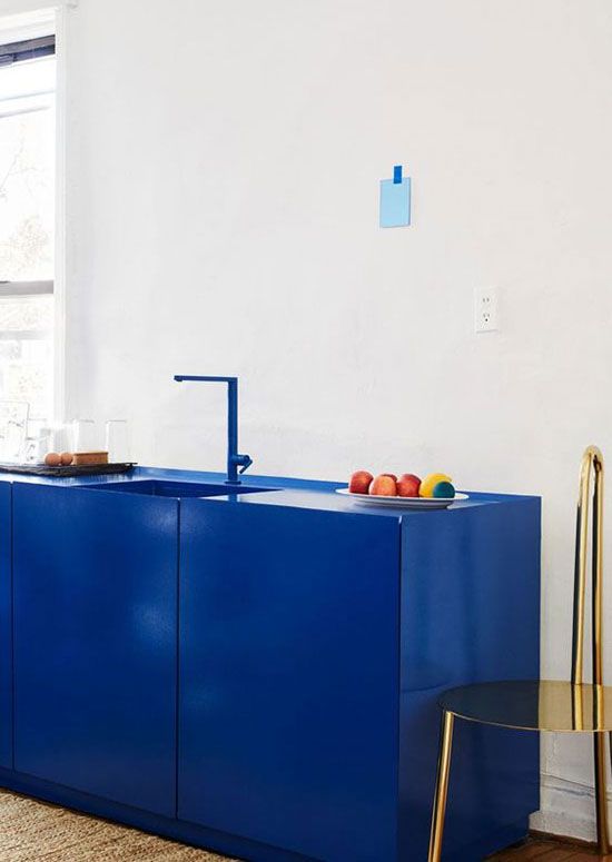 Une cuisine design avec des meubles et une robinetterie bleu roi