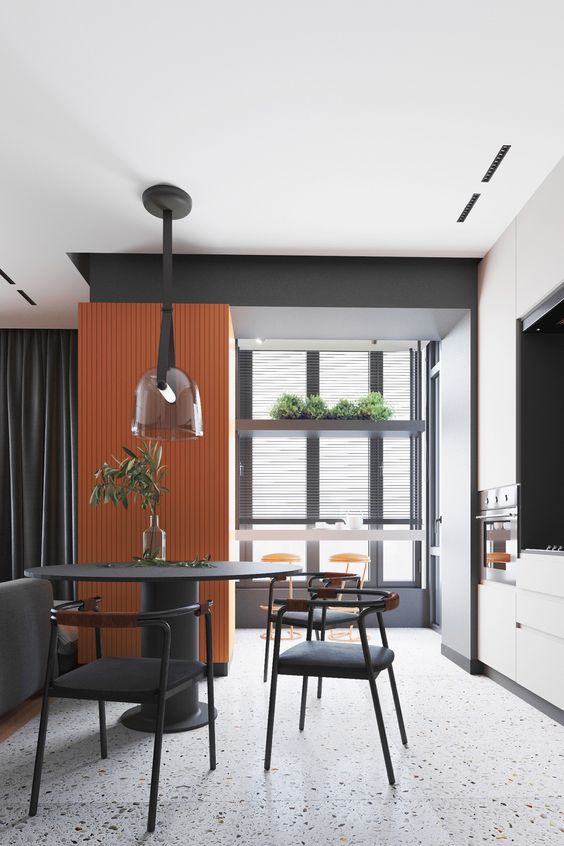 Une cuisine ouverte blanche avec une deco noir et orange