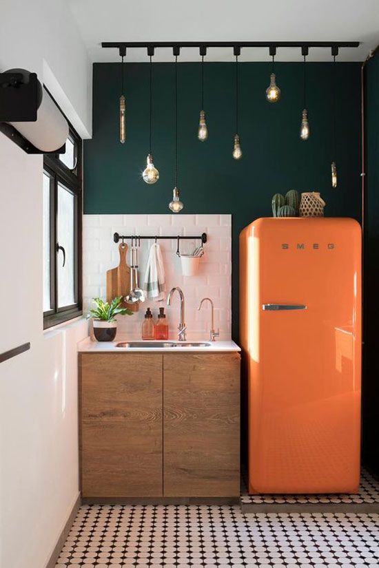 une petite cuisine avec un frigo orange