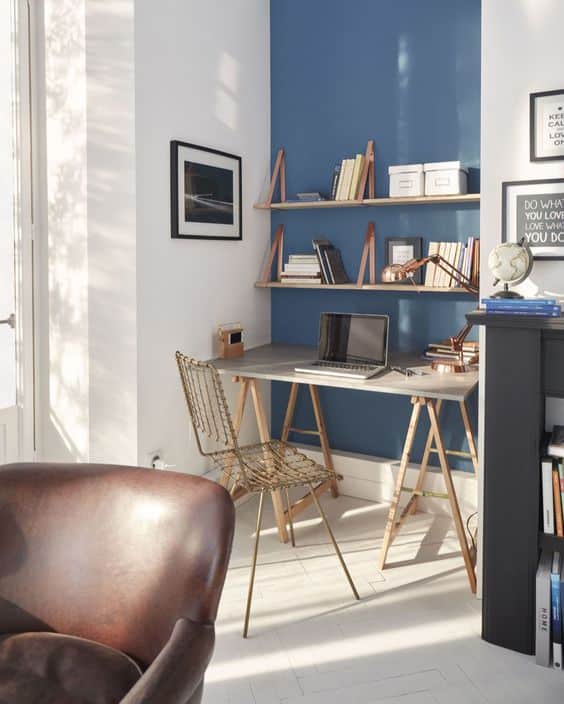 un bureau blanc face à un mur bleu
