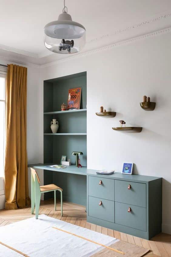 Un coin bureau bleu installé dans la chambre