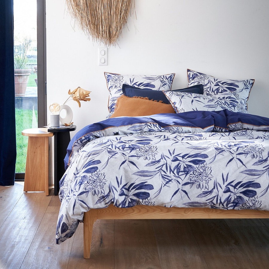 une chambre moderne avec linge de lit bleu lit et table de chevet gigogne en bosi