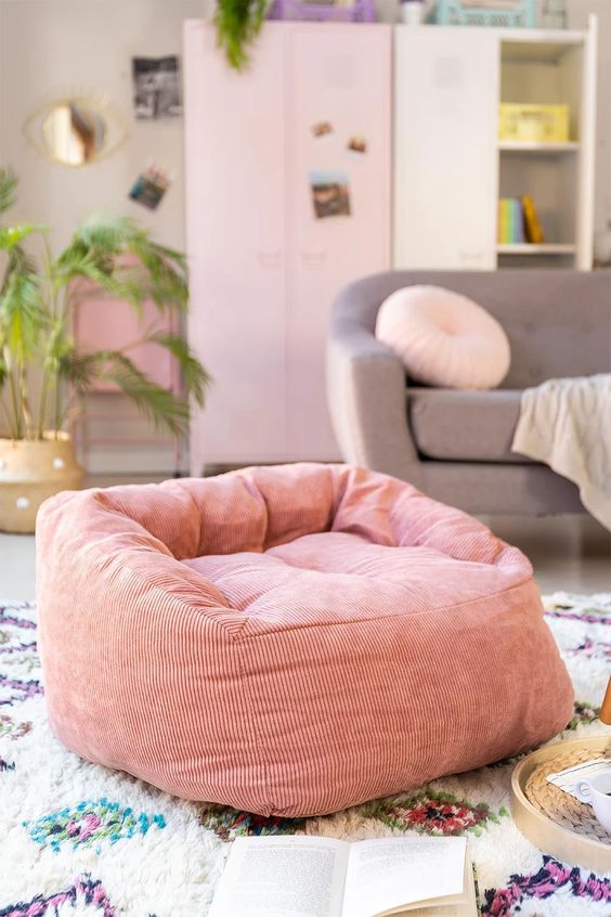 un pouf en velours cotele rose dans salon feminin