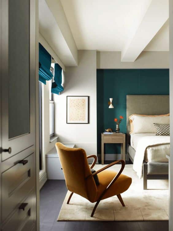 chambre moderne déco blanche avec fauteuil jaune moutarde et papier peint bleu canard
