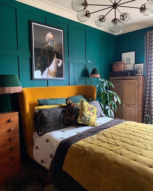 chambre vintage avec mur boiserie bleu canard et linge de lit jaune moutarde