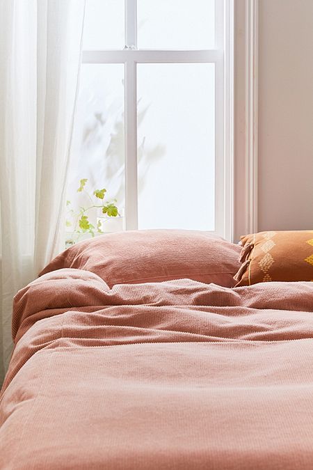 une chambre delicate avec une parure de lit en velours cotele