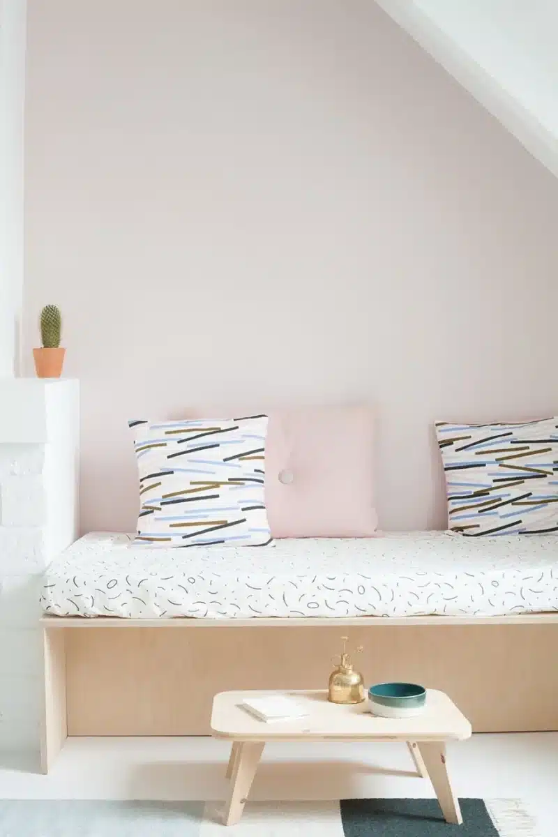banc dans une chambre avec un mur rose poudré
