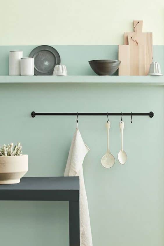 Une cuisine minimaliste avec un mur vert celadon