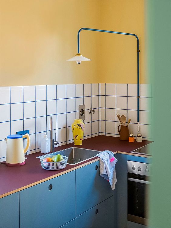 Une cuisine vintage avec crédence carreau et mur jaune