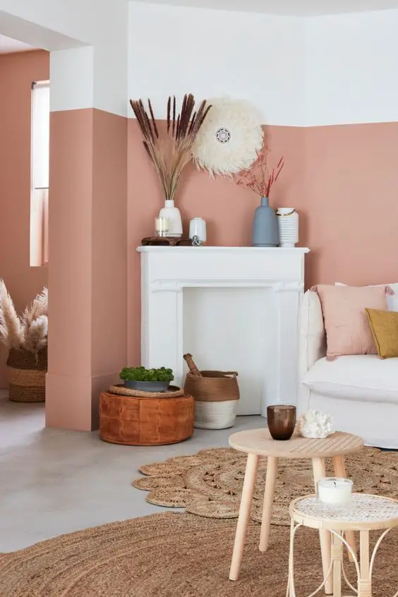 Un salon boheme chic avec un mur rose saumon