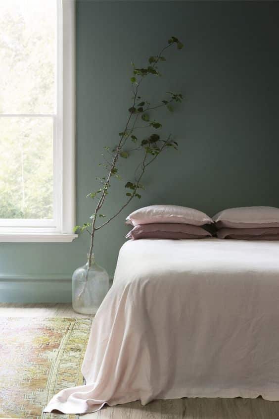 chambre minimaliste avec un mur couvert de peinture vert céladon