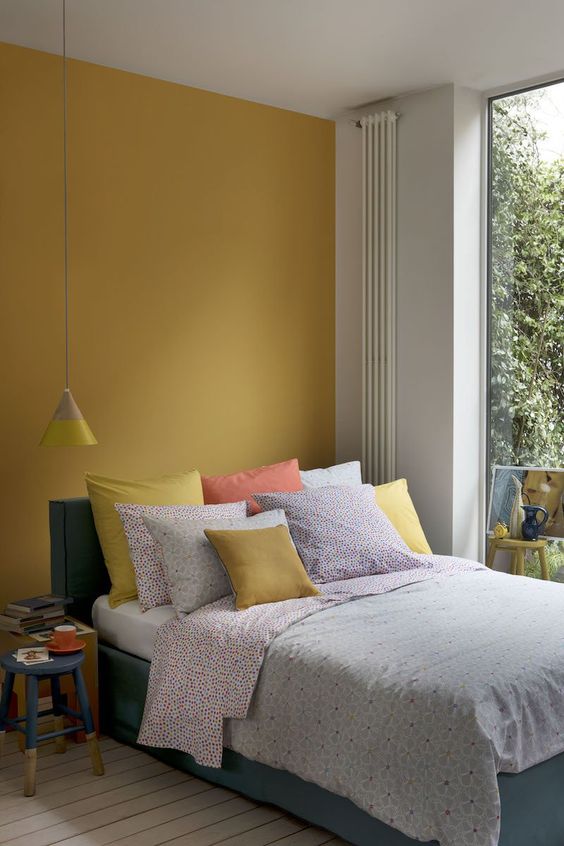 chambre minimaliste et colorée contenant du jaune moutarde
