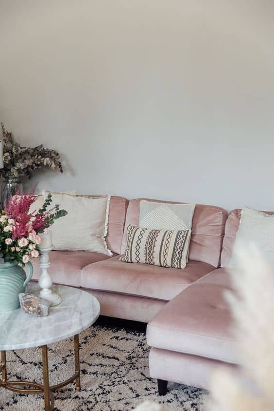un salon avec un canape en velours rose