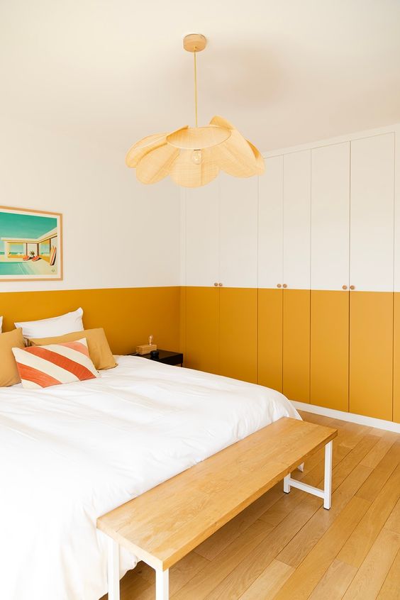 Une chambre moderne avec un mur jaune moutarde et blanc