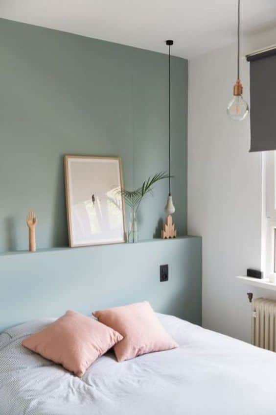 une chambre avec une tete de lit vert céladon