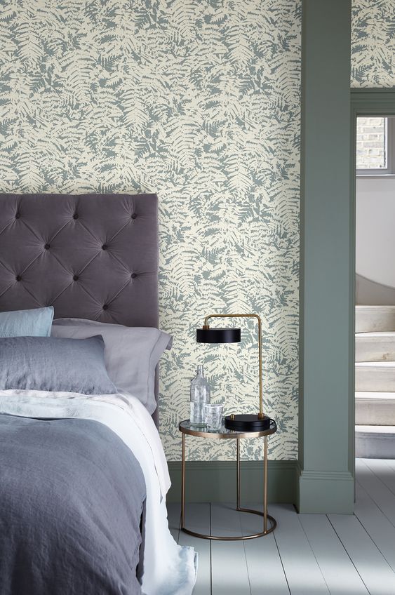 Une chambre cosy avec un papier peint vert céladon à motifs floraux