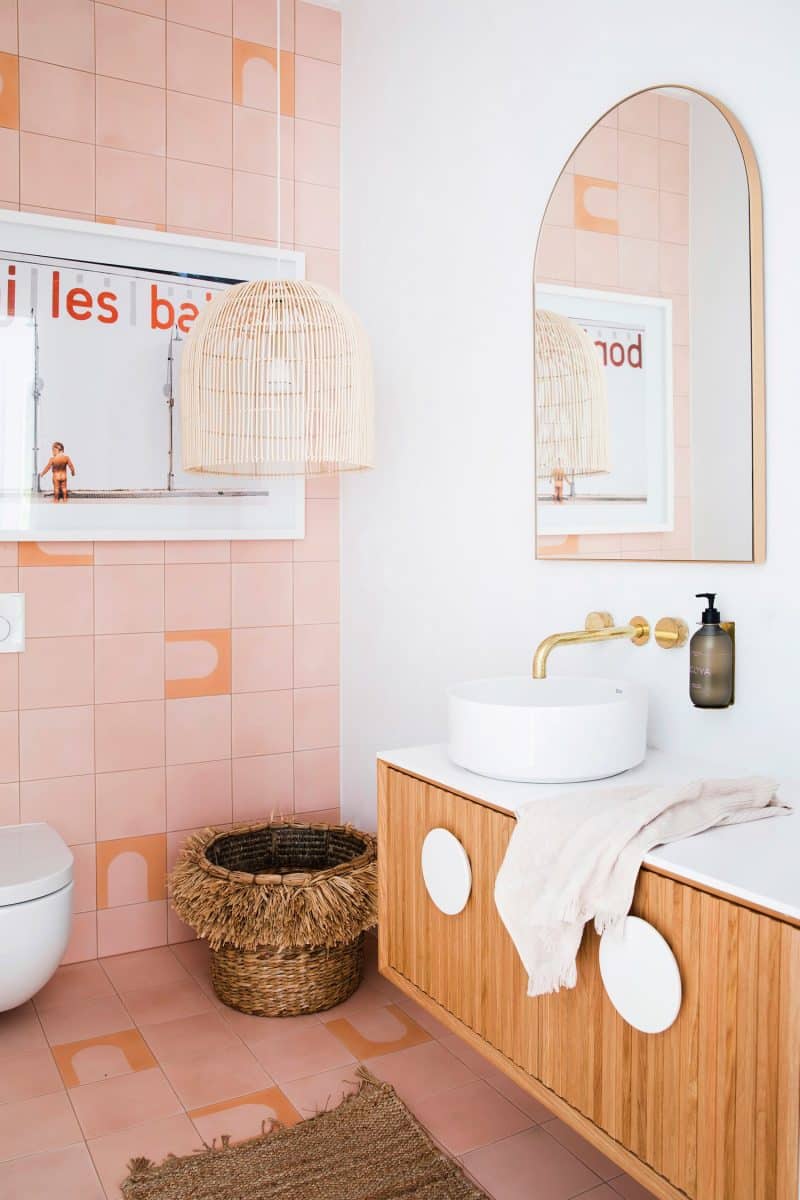 Une salle de bain graphique avec un carrelage rose