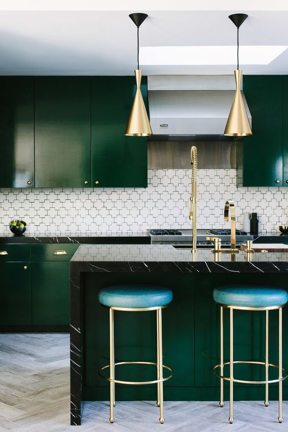 Une cuisine vert sapin avec un ilôt central et un style art déco