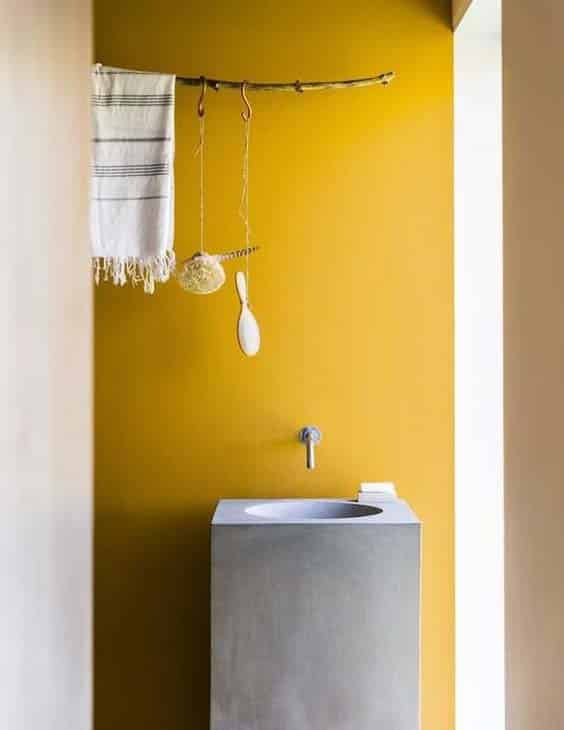 Une salle de bain minimaliste et contemporaine avec des murs jaune moutarde