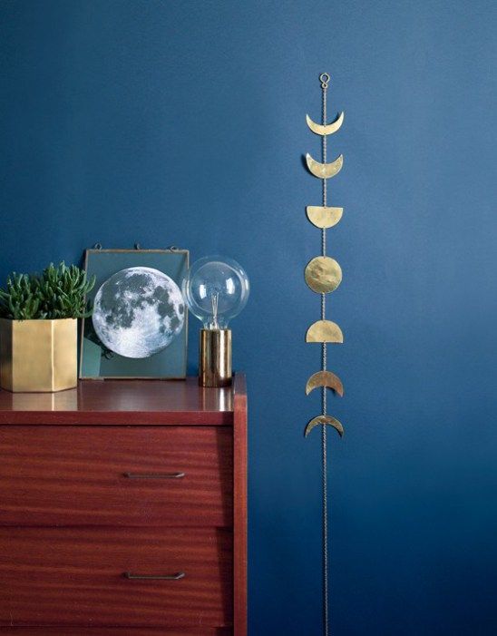 un mur bleu avec un meuble en bosi et une décoration murale en métal