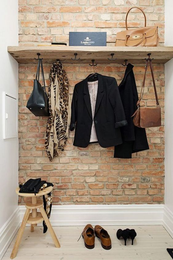Un porte manteau fabrique à la main en bois sur un mur de brique