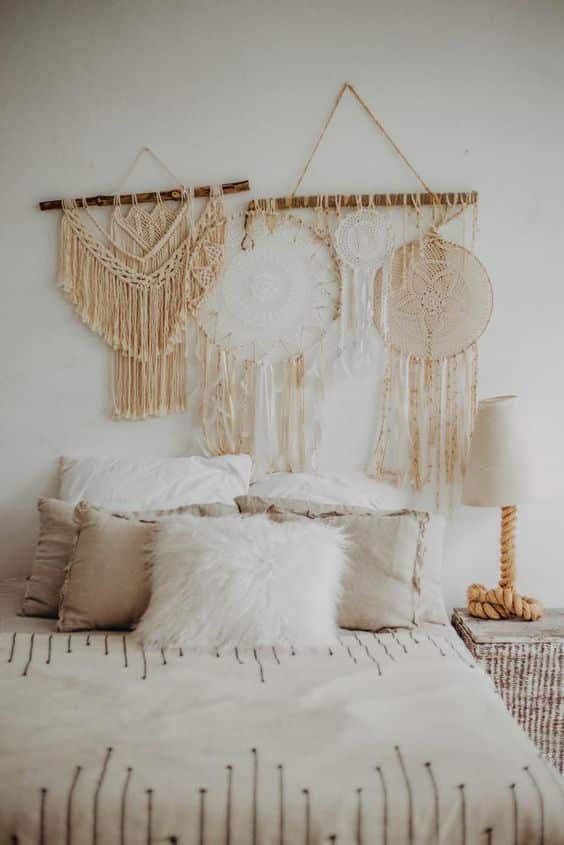 Une chambre blanche avec une tete de lit en macrame tres boheme