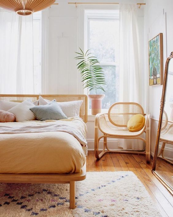 Une chambre boème avec des meubles en bois et rotin