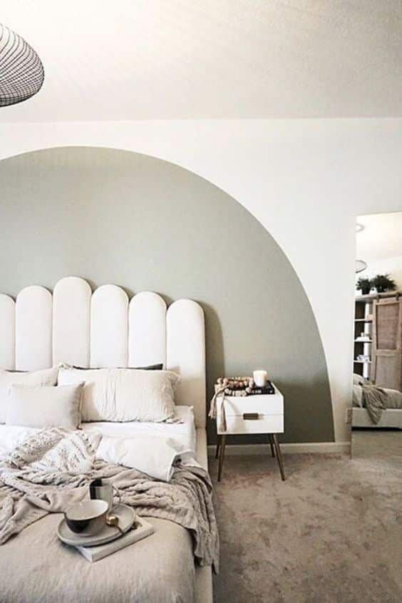 Une chambre design blanche et bleu pastel avec une tete de lit en velours