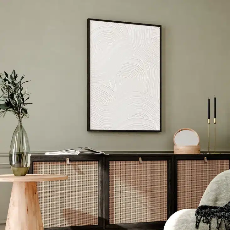 Tableau texture blanc en enduit au dessus d'un meuble en cannage dans un salon