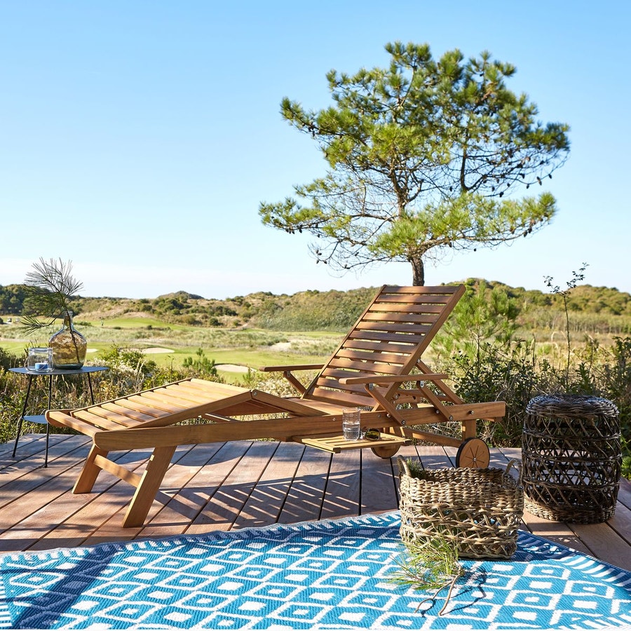 Chaise longue en bois sur terrasse en bois avec tapis exterieur bleu