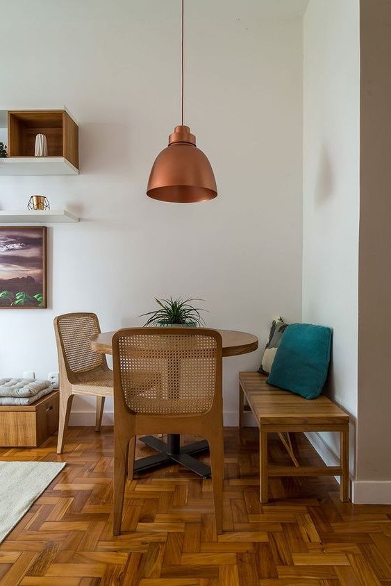 Coin repas avec banc et chaise en bois dans un angle du salon