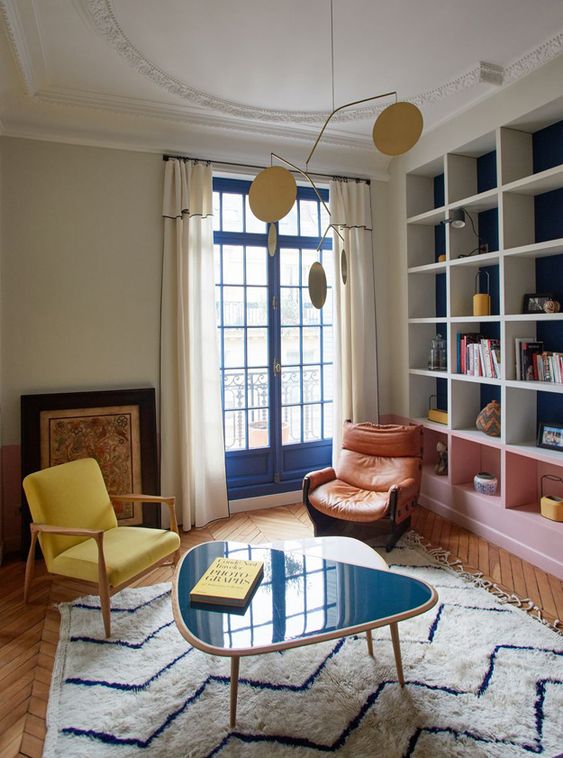Salon coloré petit et carré avec grande bibliothèque