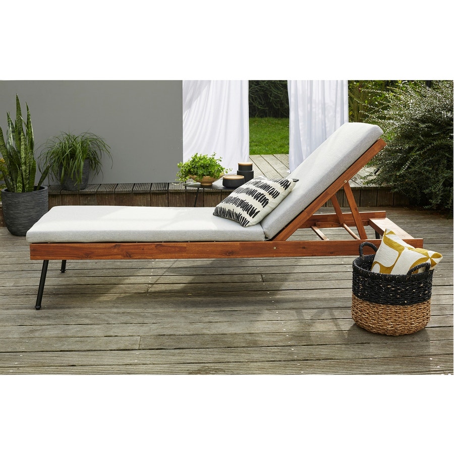 Une chaise longue en bois avec pied en metal sur une terrasse