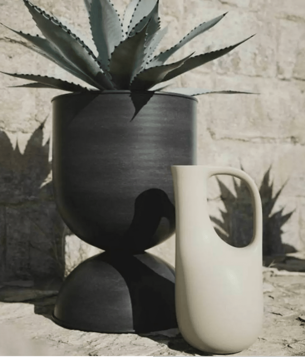 arrosoir moderne au coté d'un pot de fleur noir avec ale verra dans jardin 