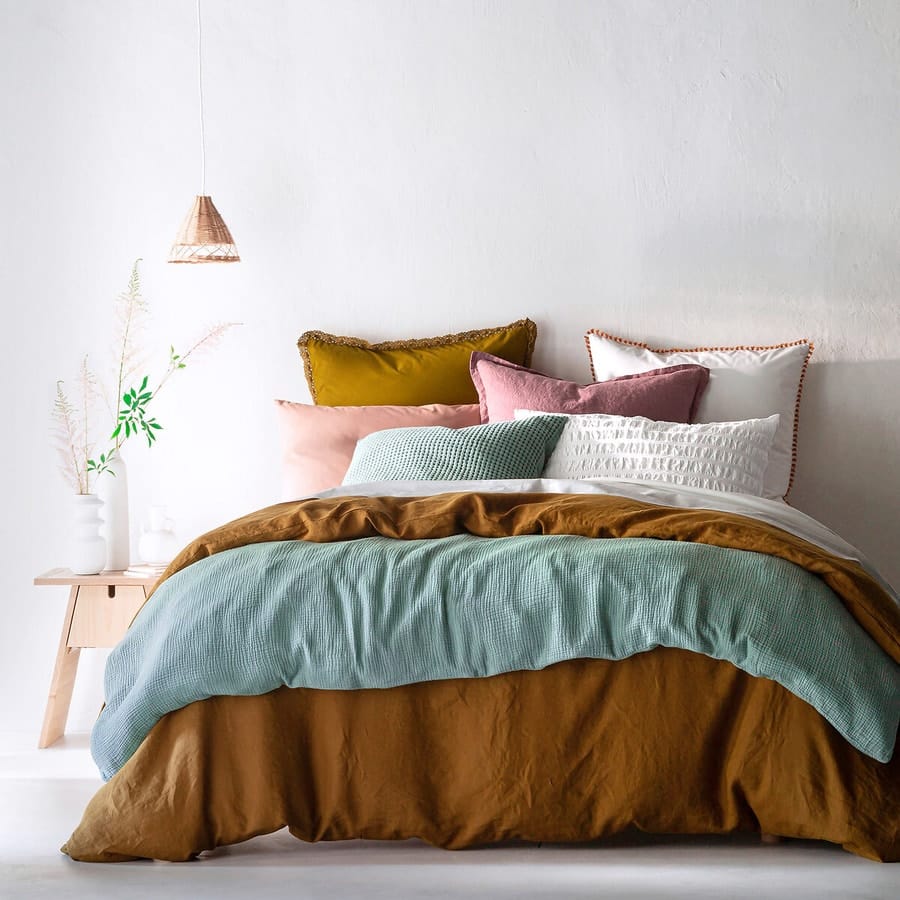 Un lit cosy et coloré avec un linge de lit en lin