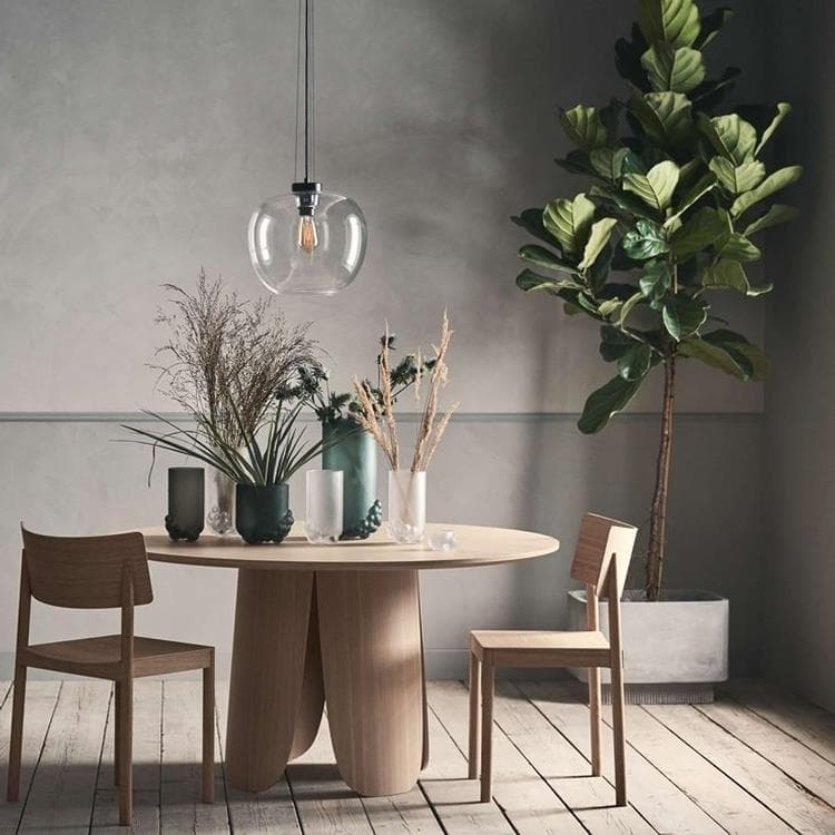 Une salle à manger design avec table en bois clair et suspension grape wide de Bolia