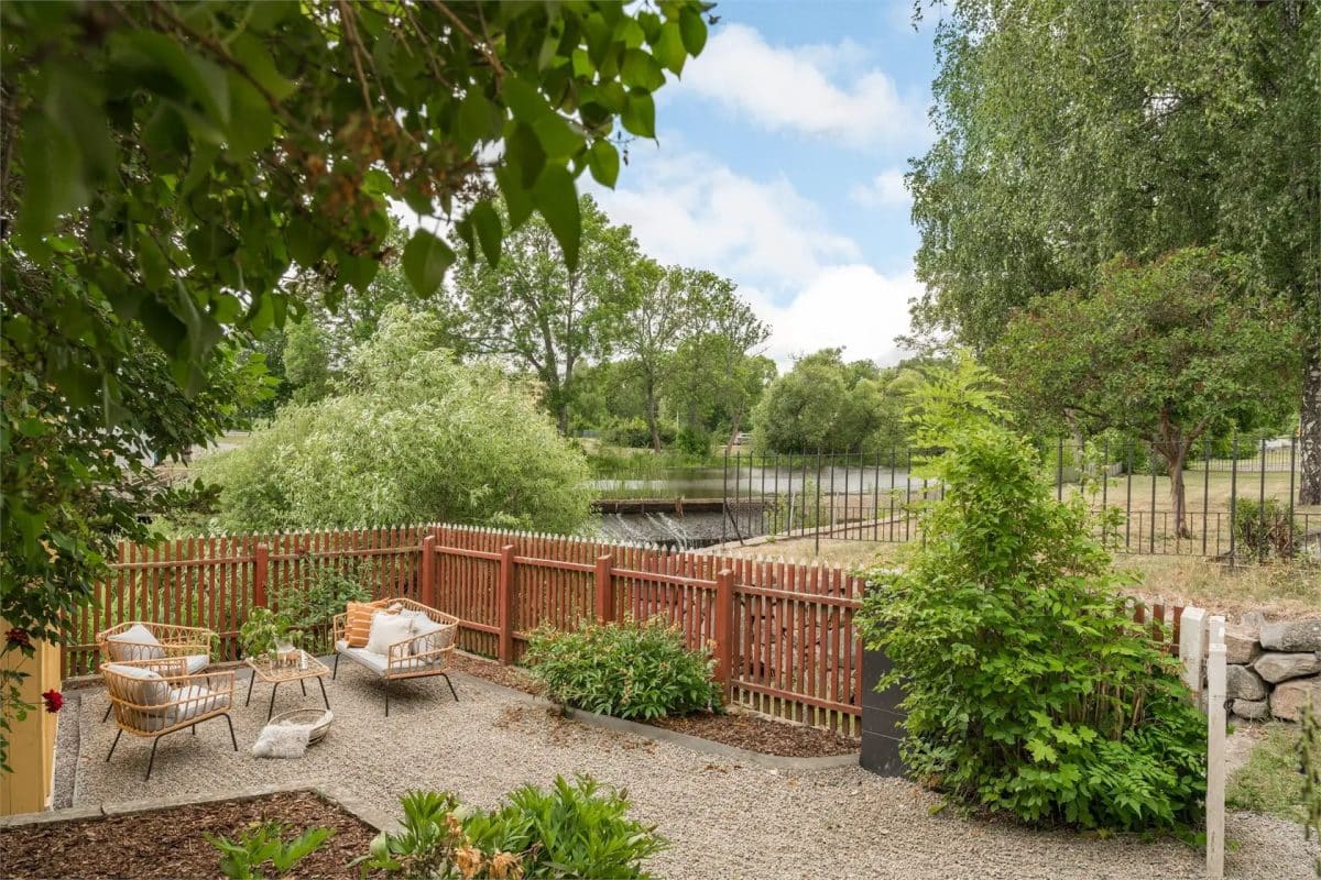 pont dans  le jardin d'une charmante maison scandinave de 35 m² en bois teinté de jaune