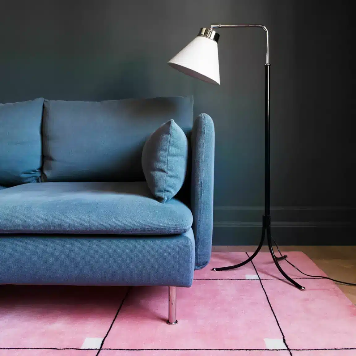 Un salon bleu nuit avec un tapis rose bonbon