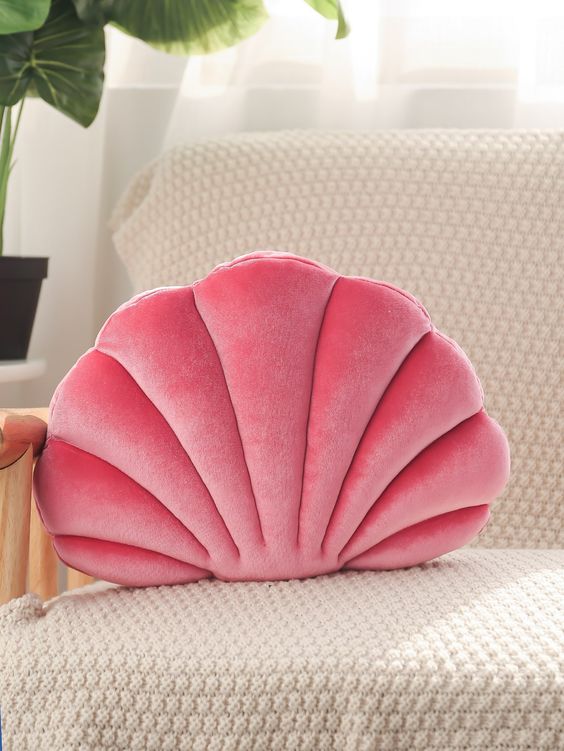 coussin coquillage rose sur fauteuil beige