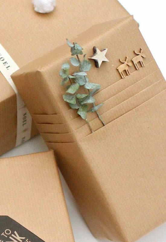 Un cadeau avec un papier kraft et des petites décorations en bois