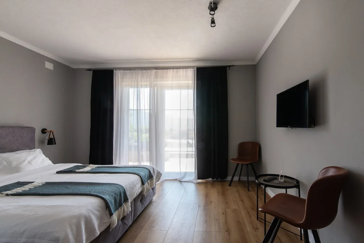 Chambre avec un téléviseur fixé au mur en face du lit
