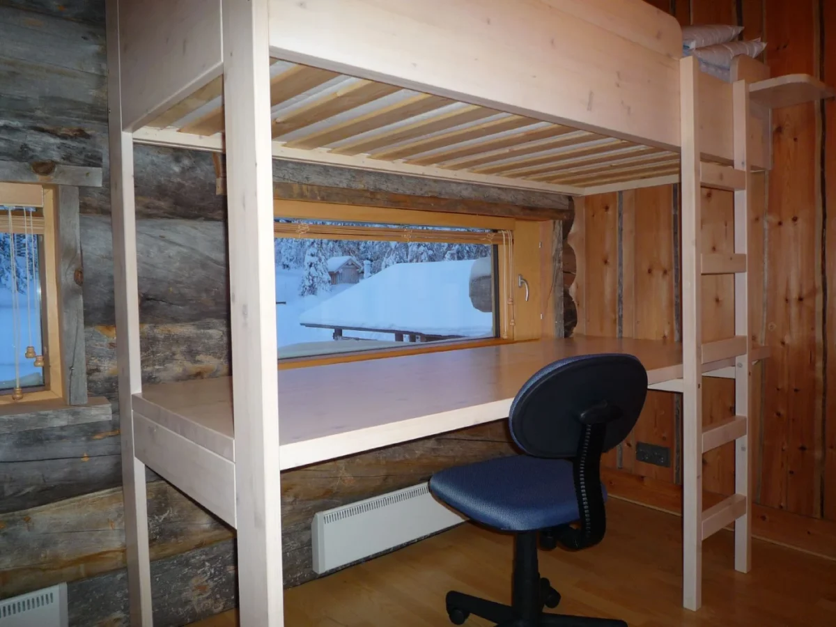 Lit mezzanine en bois clair avec un long plan de travail et une chaise de bureau dessous