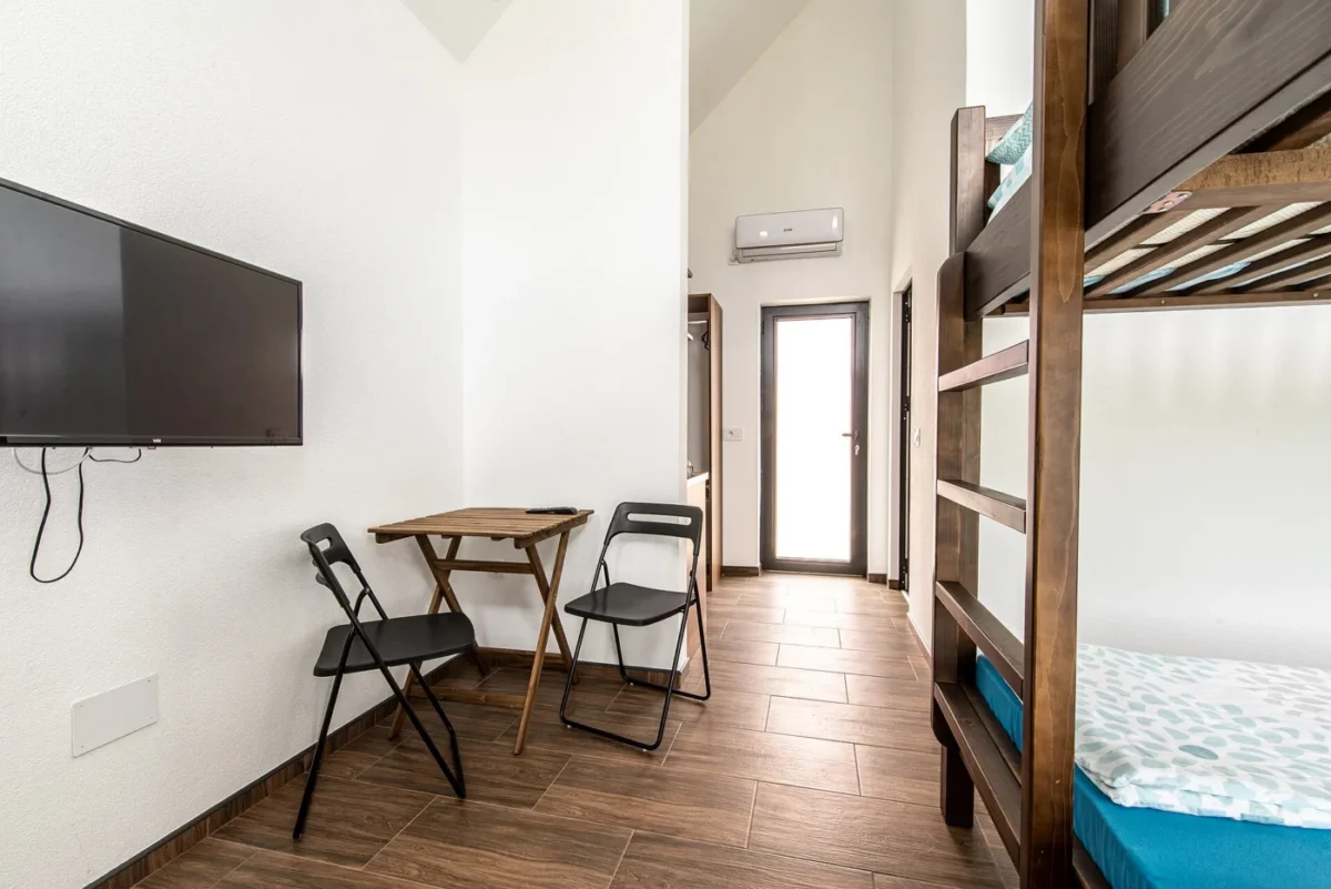 Téléviseur fixé au mur d'une chambre, avec un câble apparent